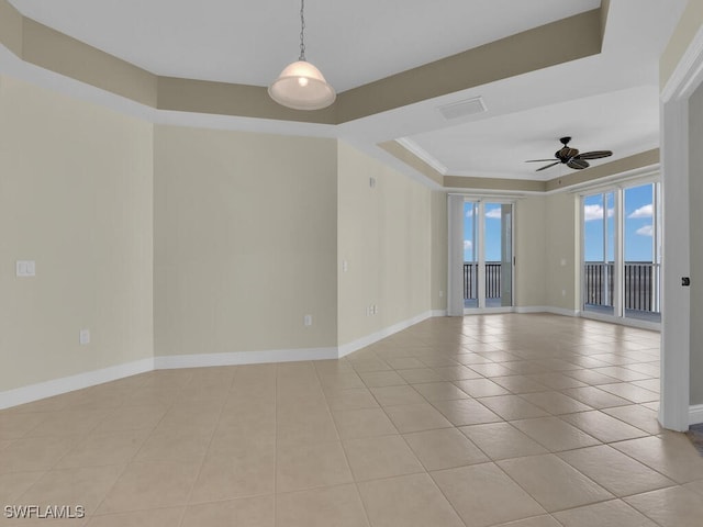 spare room with light tile patterned floors, a tray ceiling, ceiling fan, and crown molding