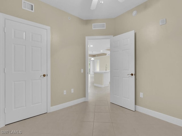 spare room with ceiling fan and light tile patterned floors