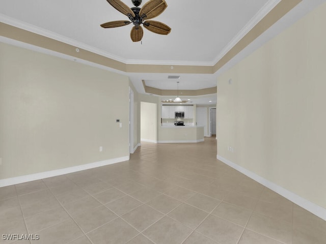 unfurnished living room with ceiling fan, a raised ceiling, light tile patterned floors, and ornamental molding