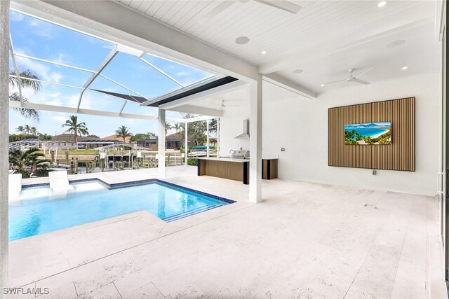 view of swimming pool with ceiling fan, an outdoor kitchen, a lanai, an outdoor bar, and a patio