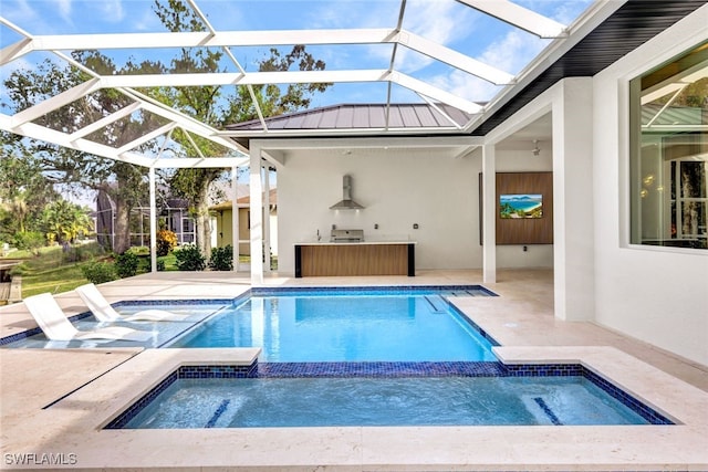 view of swimming pool with a patio area, a lanai, and exterior kitchen