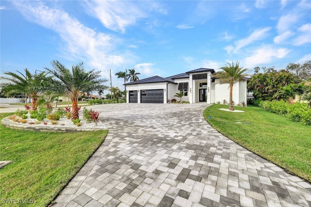 view of front of home with a garage and a front lawn