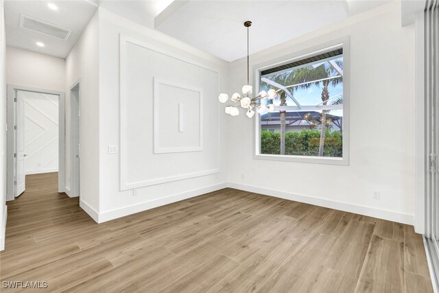 unfurnished dining area with an inviting chandelier and light wood-type flooring