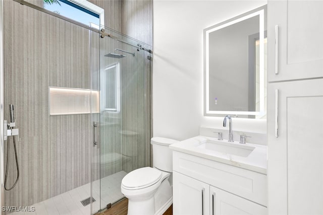 bathroom featuring vanity, an enclosed shower, and toilet