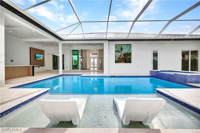 view of pool featuring glass enclosure, a patio area, and a pool with connected hot tub