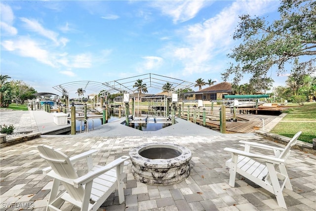 view of patio featuring a dock, a fire pit, and boat lift