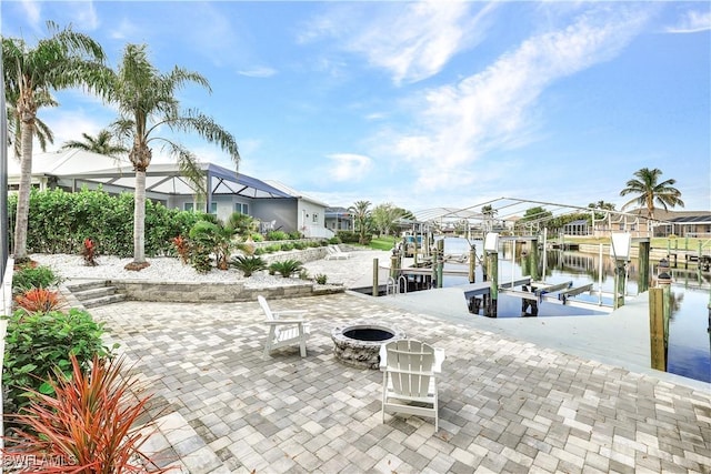 view of patio / terrace with an outdoor fire pit, boat lift, a water view, a residential view, and a dock