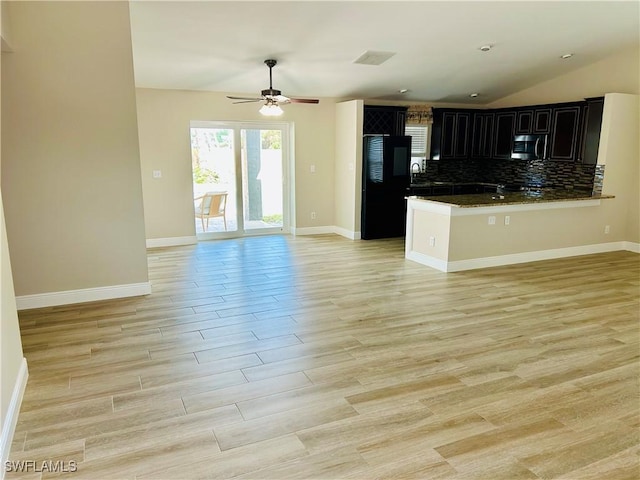 kitchen with ceiling fan, tasteful backsplash, kitchen peninsula, lofted ceiling, and black refrigerator