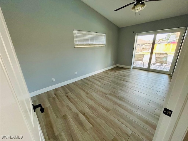 spare room with vaulted ceiling, light hardwood / wood-style flooring, and ceiling fan