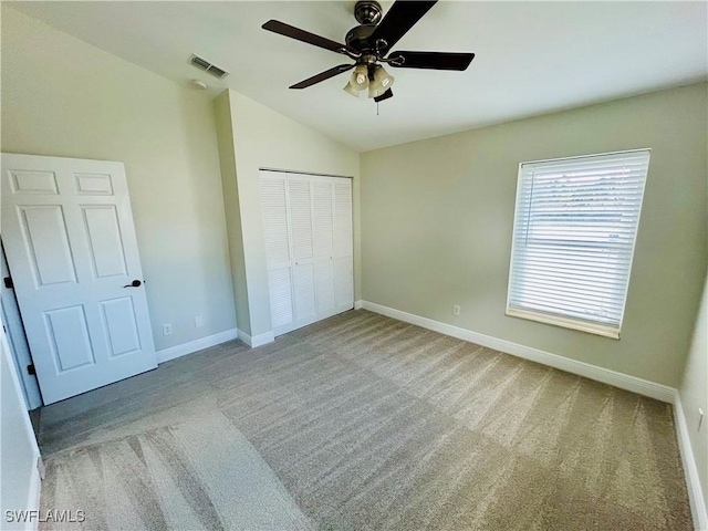 unfurnished bedroom with ceiling fan, light carpet, and a closet