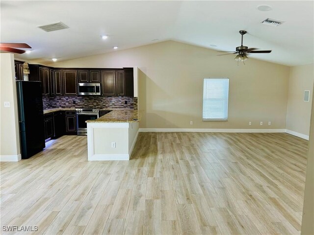 kitchen with lofted ceiling, light hardwood / wood-style flooring, decorative backsplash, light stone counters, and stainless steel appliances