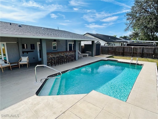 view of pool with a patio area and a bar