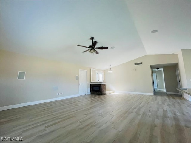 unfurnished living room with ceiling fan with notable chandelier, light hardwood / wood-style floors, and lofted ceiling