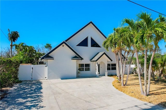 309 Donora Blvd, Fort Myers Beach, FL 33931 - view of front of home featuring driveway, a gate, and stucco siding