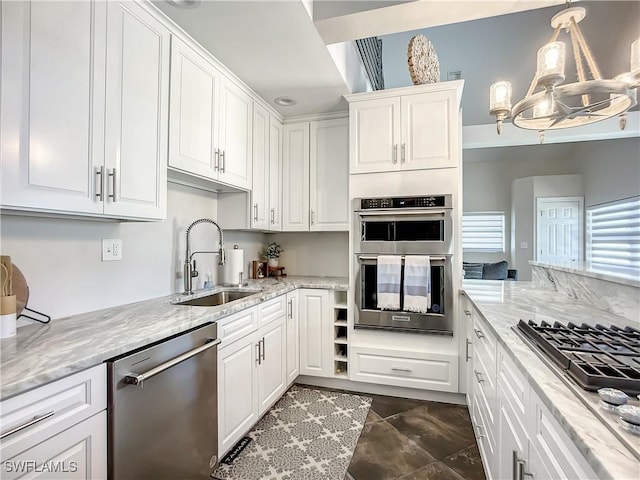309 Donora Blvd, Fort Myers Beach, FL 33931 - kitchen featuring appliances with stainless steel finishes, light stone countertops, white cabinetry, pendant lighting, and a sink