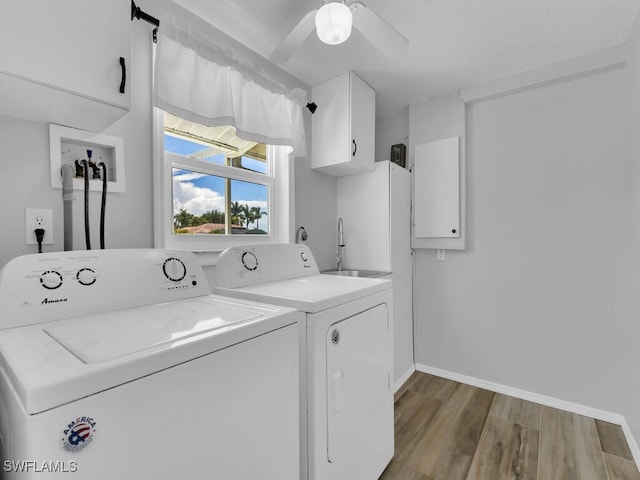 laundry area featuring cabinets, light wood-type flooring, washer and clothes dryer, ceiling fan, and sink