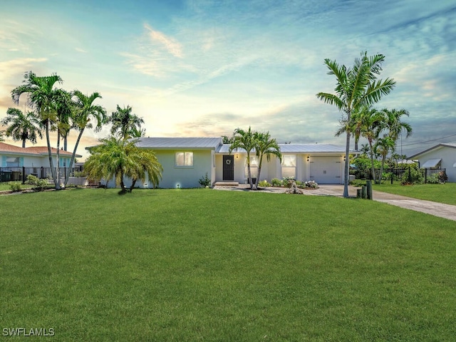 ranch-style house with a yard and a garage