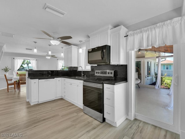 kitchen with kitchen peninsula, electric range, white dishwasher, and white cabinets