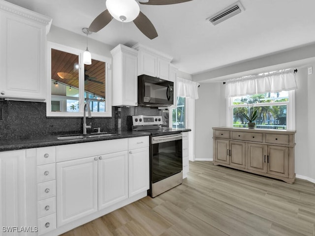 kitchen with decorative backsplash, sink, white cabinets, and stainless steel range with electric stovetop