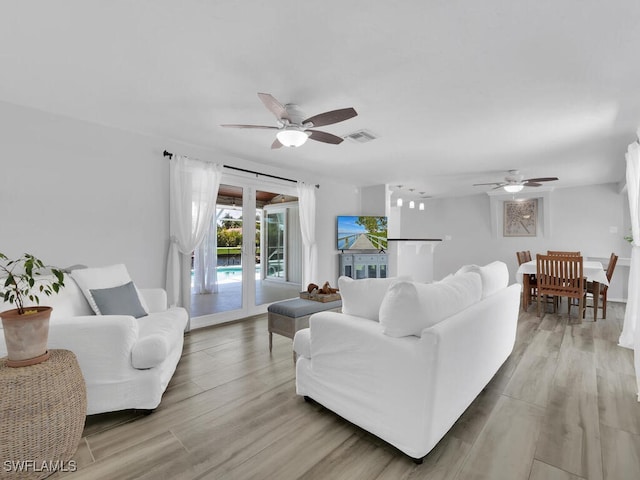 living room featuring light hardwood / wood-style floors and ceiling fan