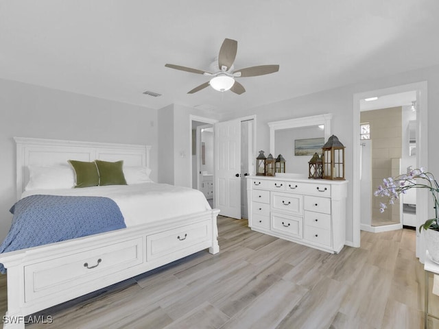 bedroom with ensuite bathroom, ceiling fan, and light hardwood / wood-style flooring