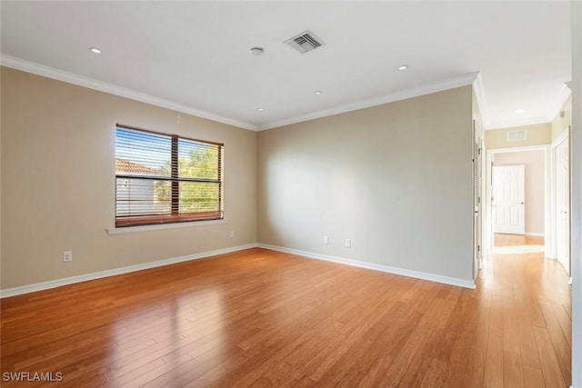 unfurnished room with baseboards, crown molding, visible vents, and light wood-style floors