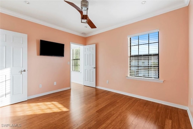 unfurnished bedroom with a ceiling fan, baseboards, crown molding, and wood finished floors