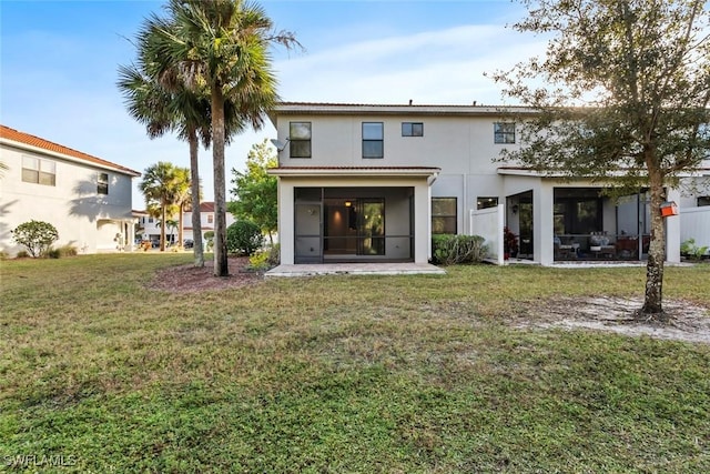 back of property featuring a sunroom, stucco siding, and a yard