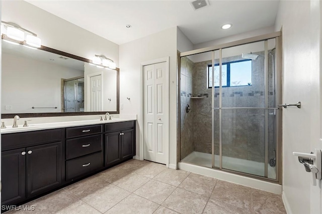 bathroom with visible vents, a sink, and a shower stall