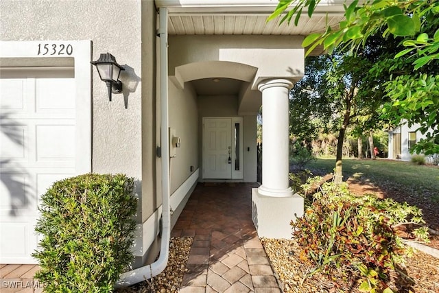 doorway to property featuring stucco siding