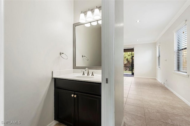 bathroom featuring tile patterned flooring, ornamental molding, baseboards, and vanity