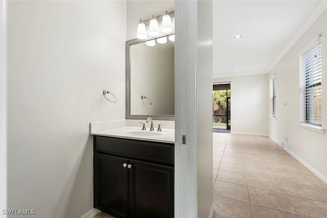 bathroom featuring crown molding, tile patterned floors, baseboards, and vanity