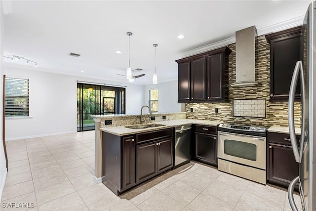 kitchen featuring decorative backsplash, a peninsula, stainless steel appliances, wall chimney range hood, and a sink