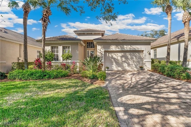 mediterranean / spanish home with a front lawn and a garage