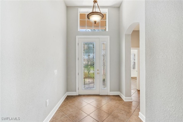 entrance foyer featuring a towering ceiling and light tile patterned flooring