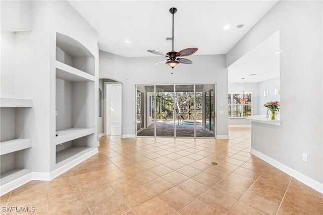 unfurnished living room featuring built in shelves, ceiling fan, and light tile patterned floors