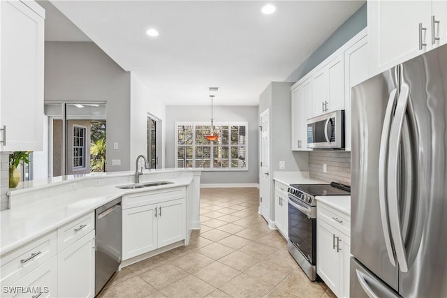 kitchen with white cabinets, stainless steel appliances, tasteful backsplash, and sink