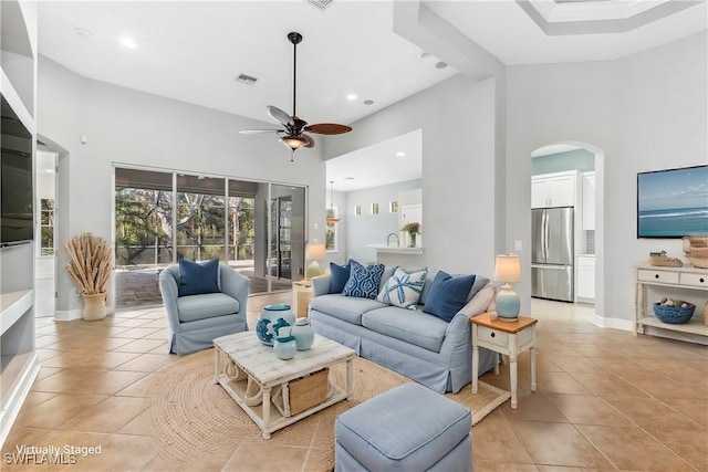 tiled living room featuring ceiling fan and high vaulted ceiling