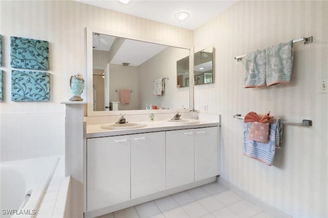 bathroom featuring vanity, tile patterned floors, and tiled tub