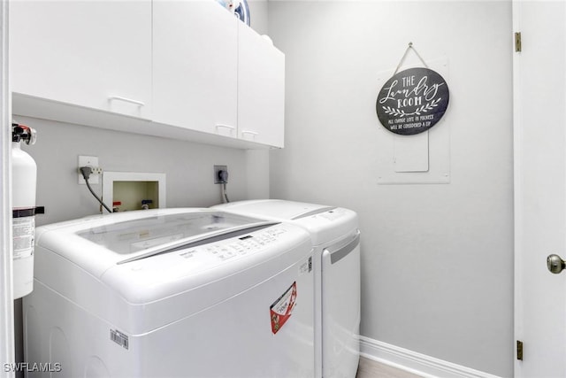 washroom featuring washer and dryer and cabinets