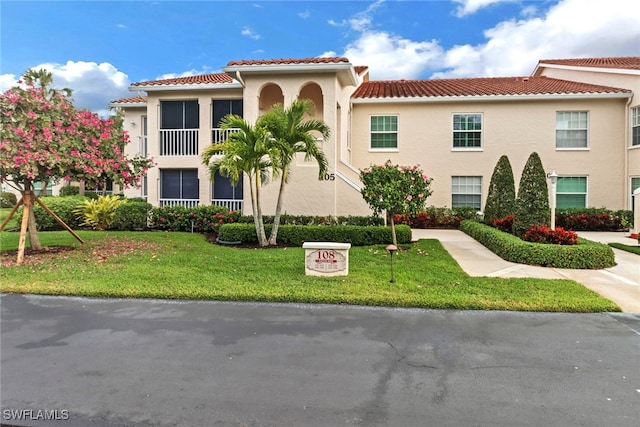 mediterranean / spanish home with a front lawn