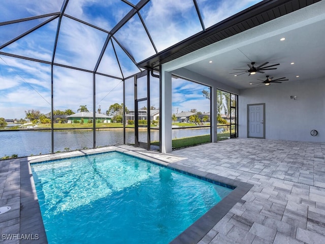 view of swimming pool featuring a patio, a water view, ceiling fan, and a lanai