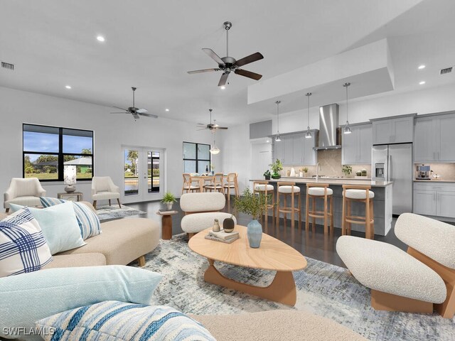 living room featuring sink, wood-type flooring, french doors, and ceiling fan