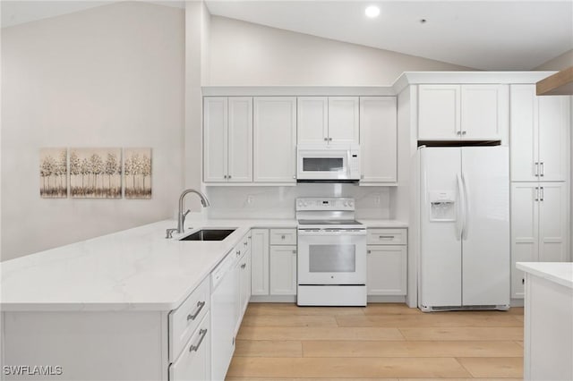 kitchen with white cabinetry, white appliances, sink, and vaulted ceiling