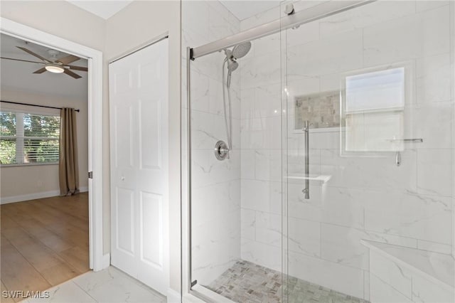 bathroom with a shower with door and ceiling fan