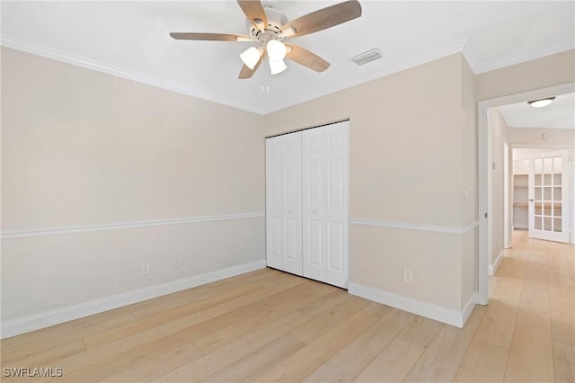 unfurnished bedroom featuring ceiling fan, crown molding, light hardwood / wood-style flooring, and a closet