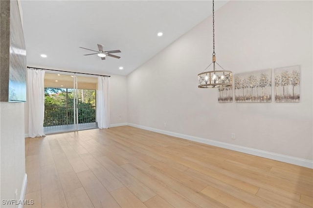 spare room featuring ceiling fan with notable chandelier and light wood-type flooring