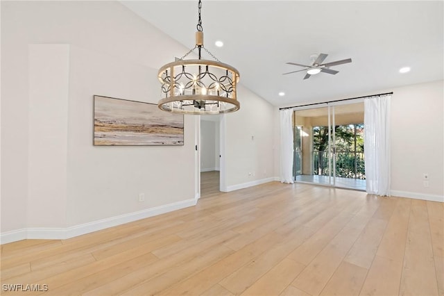 spare room with ceiling fan with notable chandelier and light wood-type flooring