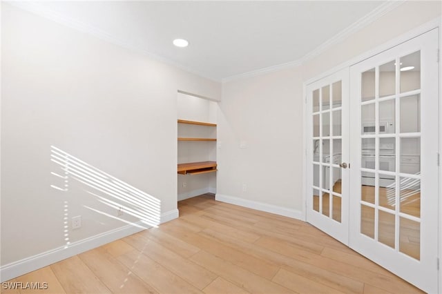 spare room with light hardwood / wood-style floors, ornamental molding, and french doors