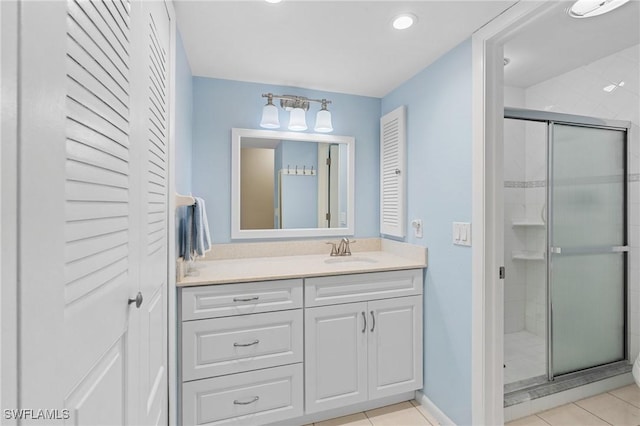 bathroom with tile patterned flooring, vanity, and a shower with shower door